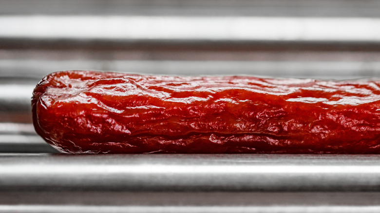 A wrinkled sausage on a gas station hot dog roller