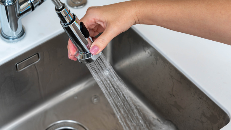 A hand cleaning kitchen sink