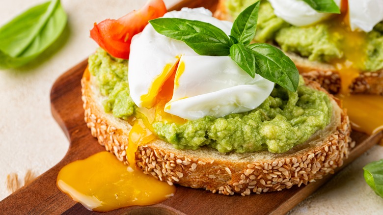 Avocado toast with poached egg with flowing yolk