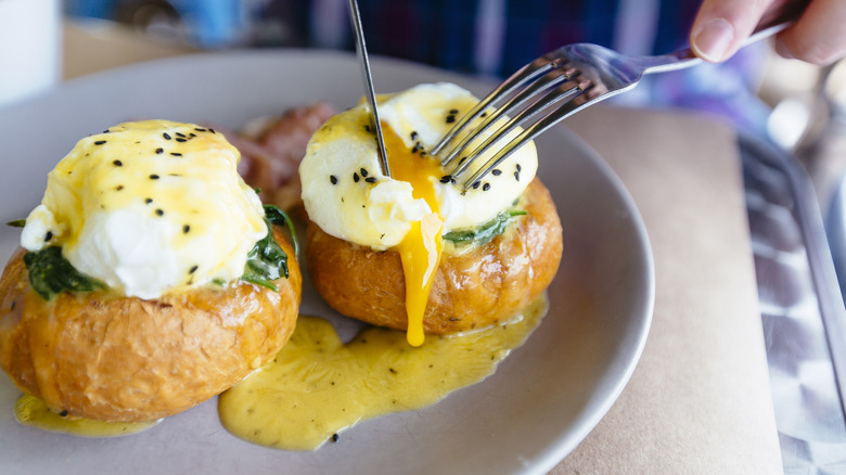Person cutting into poached eggs