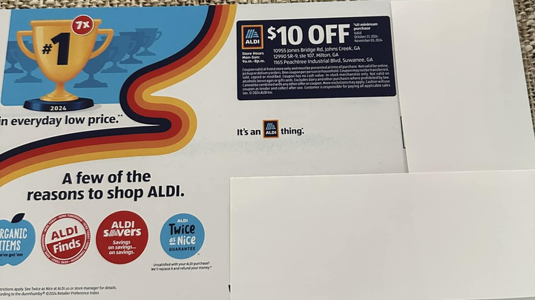 An Aldi coupon sits on a piece of upholstered furniture