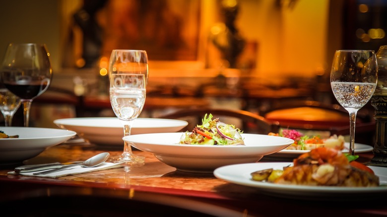 Dishes and glasses with food and drinks on a table in a restaurant
