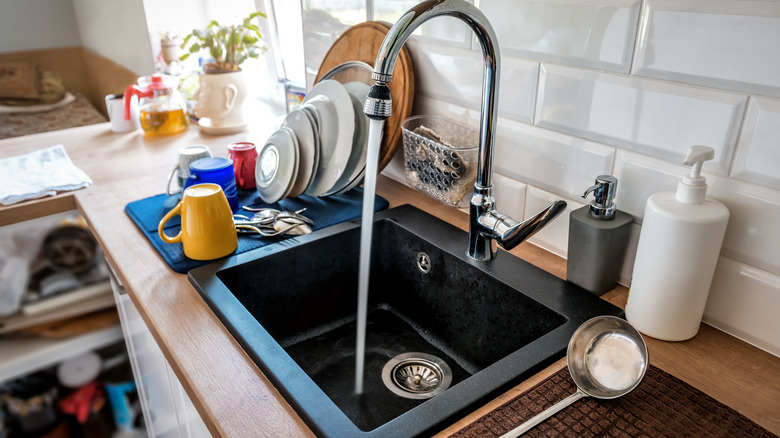 A kitchen sink with water flowing.