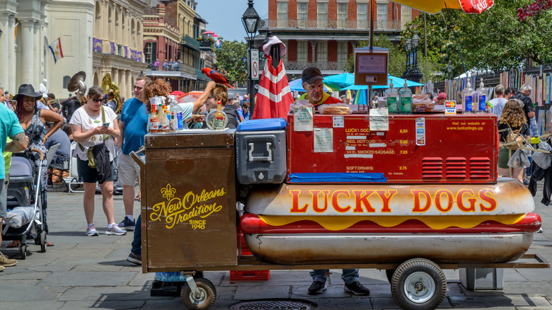 A vendor stands with a Lucky Dogs food cart in Jackson Square, New Orleans, LA.