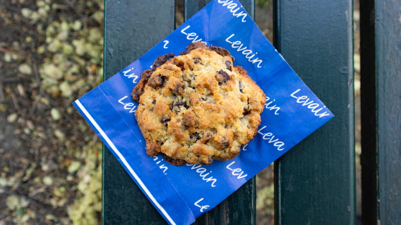 A Levain cookie sitting on a bench.
