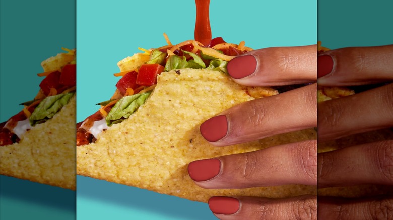 Pouring Taco Bell sauce on a taco.