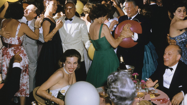 a 1950s party with people dancing and enjoying cocktails