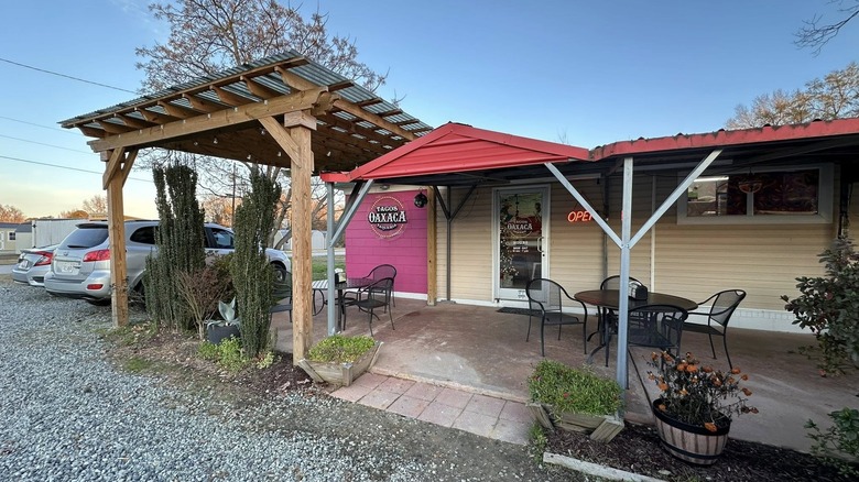 An open sign is illuminated on the Tacos Oaxaca building