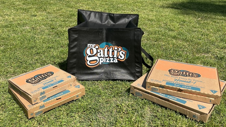 Boxes of Mr. Gatti's Pizza sit on green grass