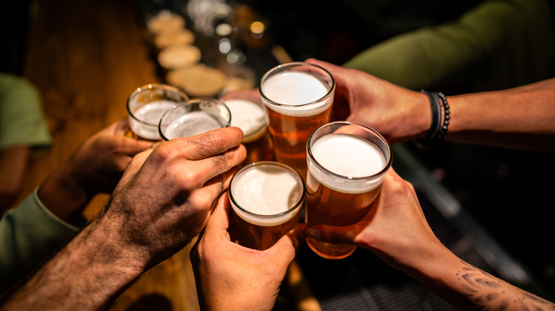 A group of people toasting with draft beers