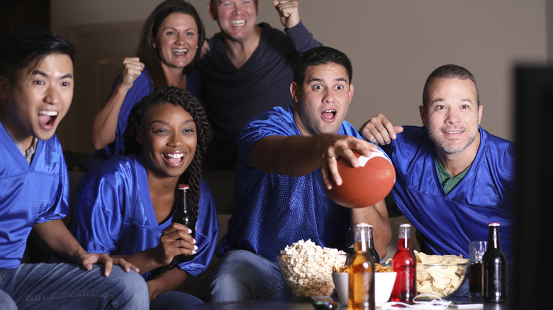 Happy friends watching a football game