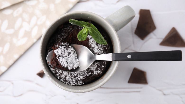 Chocolate mug cake with powdered sugar and a mint leaf