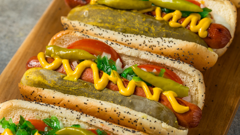 Three Chicago-style hot dogs sit on a wrapper
