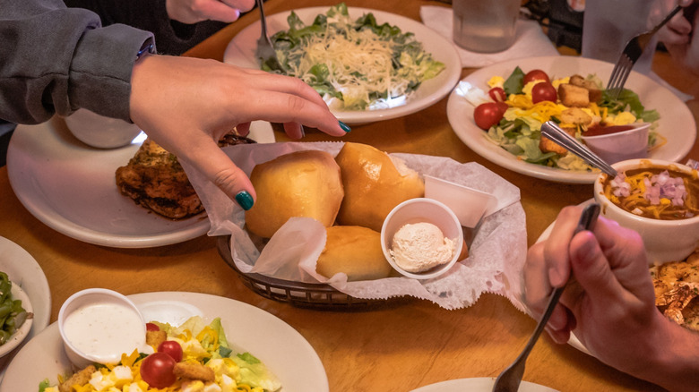 A table full of various Texas Roadhouse dishes.
