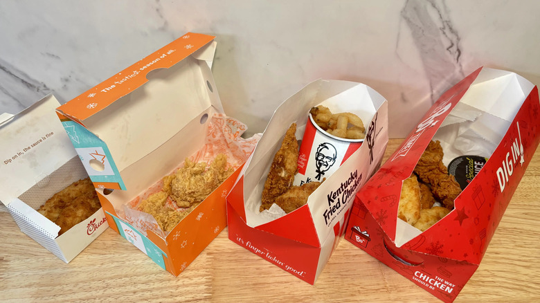 Four boxes of open fried chicken lined up in a: Chik-fil-A, Popeyes, KFC, and Bojangles.