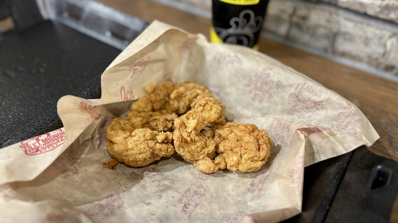 Crispy Huey Magoo's chicken tenders on an open wrapper.