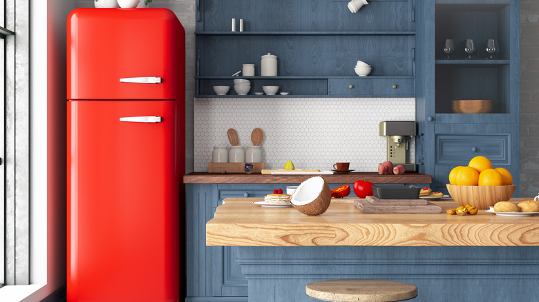 A red vintage-style refrigerator pops against blue-green cabinetry