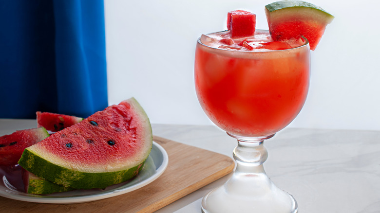 a glass of agua fresca de sandia, with watermelon as a garnish