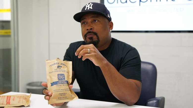 Daymond John holding packs of Three Jerks Jerky