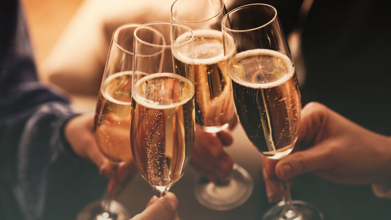 people clinking glasses with sparkling wine