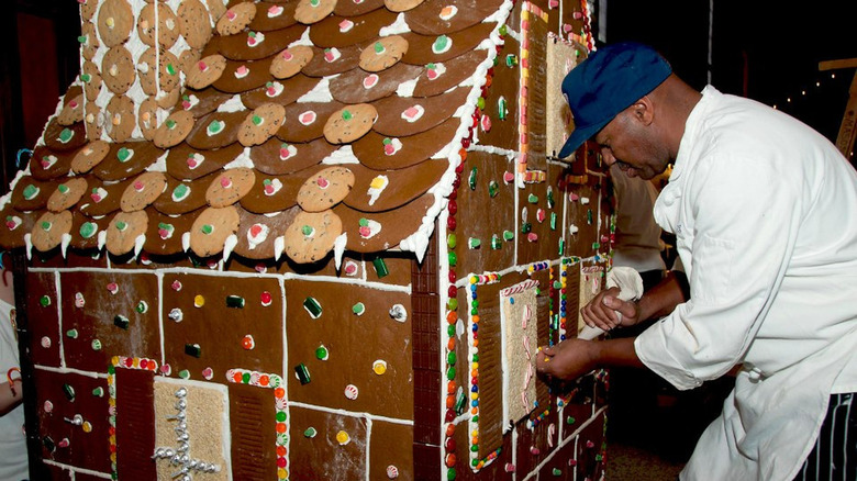 Black worker assembling giant gingerbread house for Yale
