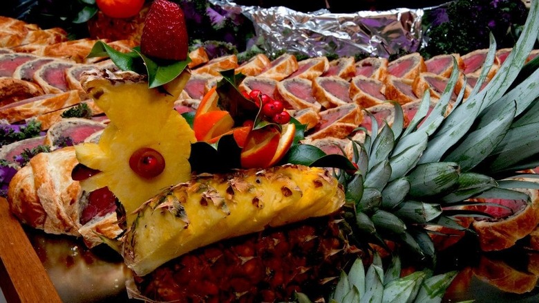 huge beef wellington next to pineapple animal