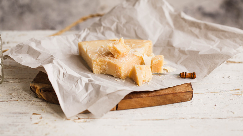 block of cheese on board with knife