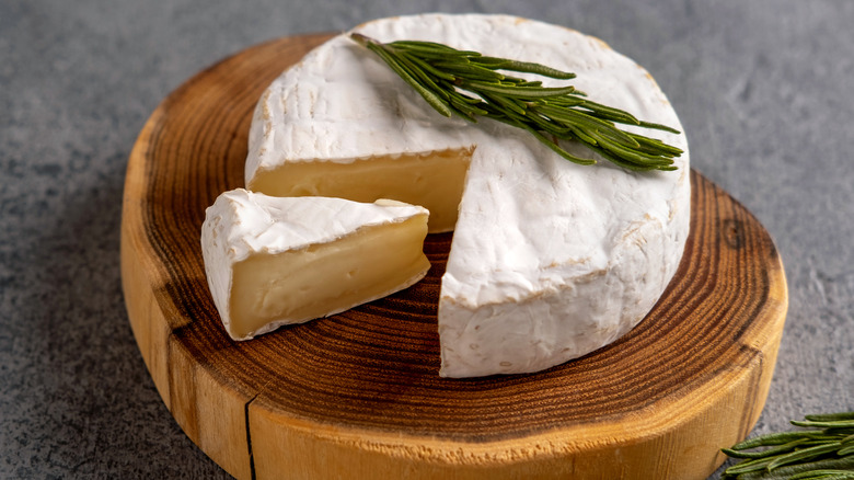 brie cheese with rosemary on a wooden block