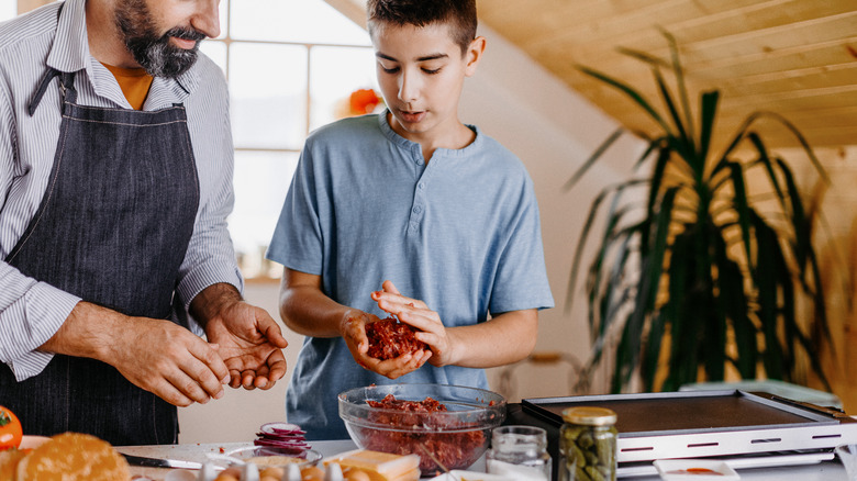 father and son making meatballs