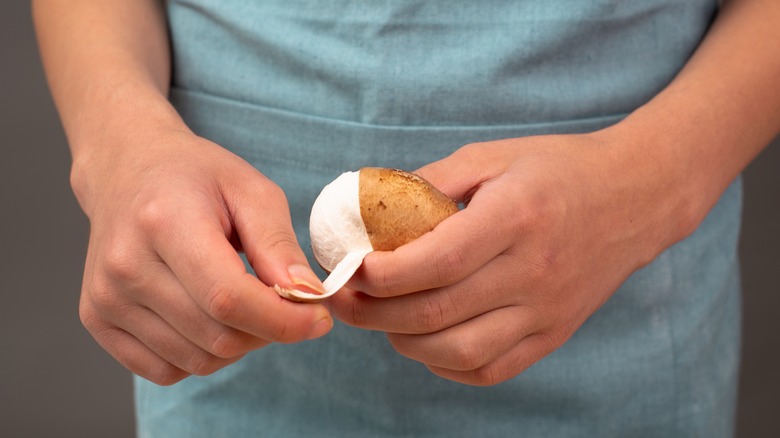 Person peeling mushroom