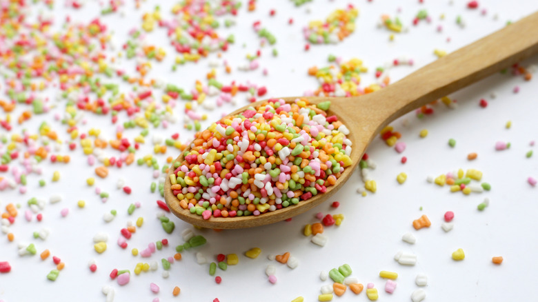 Wooden spoon overflowing with colorful sugar sprinkles