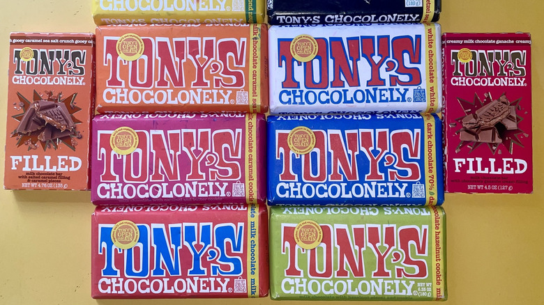 Every flavor of Tony Chocolonely Chocolate Bars laid out on a yellow tabletop