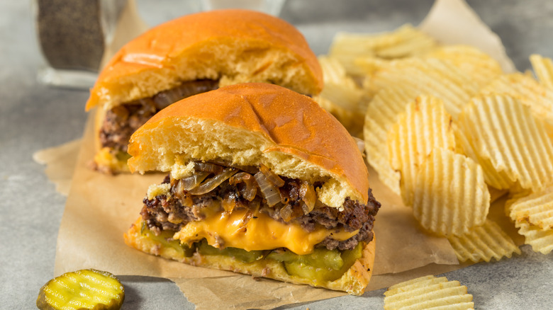 Halved juicy Lucy burger served with chips