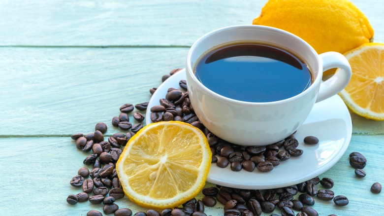 Black coffee in white cup with coffee beans