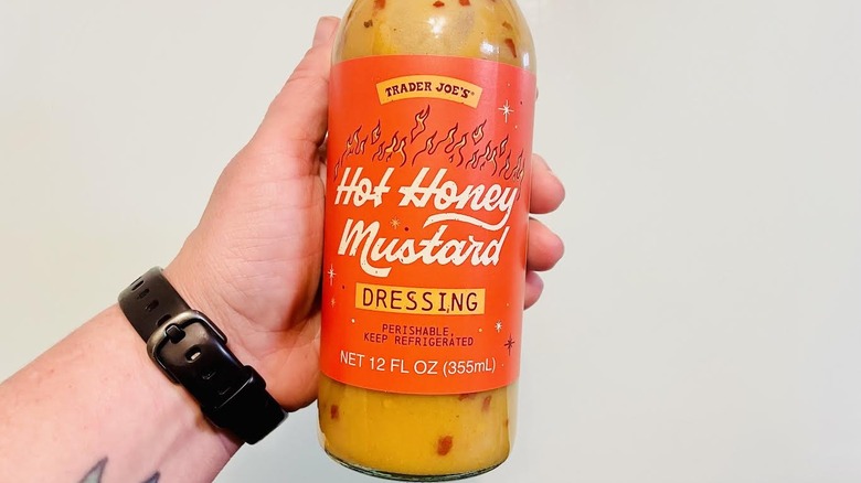 Hand holding bottle of Trader Joe's Hot Honey Mustard Dressing