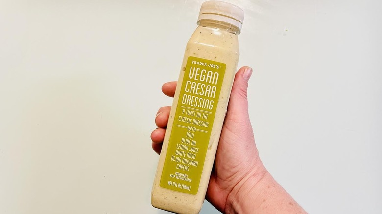 Hand holding bottle of Trader Joe's Vegan Caesar Dressing