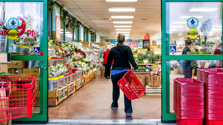 Woman with basket walking into Trader Joe's