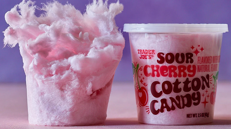 A tub of Trader Joe's Sour Cherry Cotton Candy sits next to a package-less mass of the candy