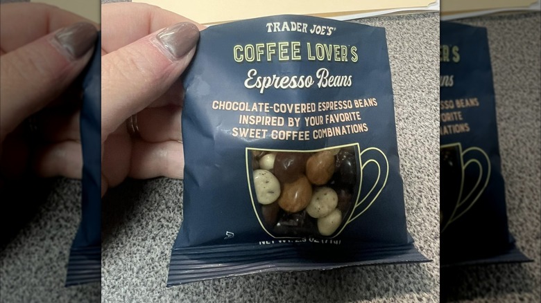 A hand holds up an opened bag of Trader Joe's espresso beans