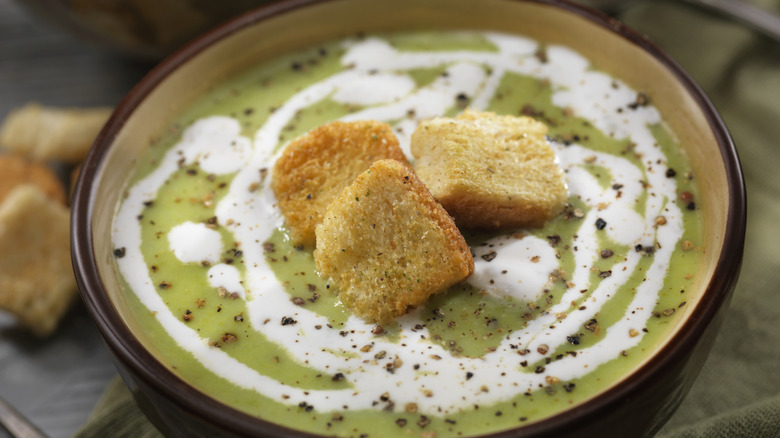 A bowl of pea soup with croutons.
