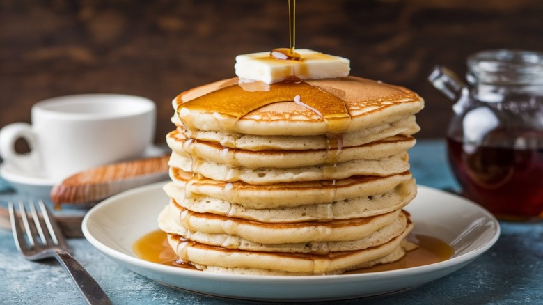 Stack of pancakes with butter and maple syrup