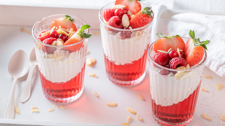 Strawberry gelatin desserts topped with whipped cream and berries