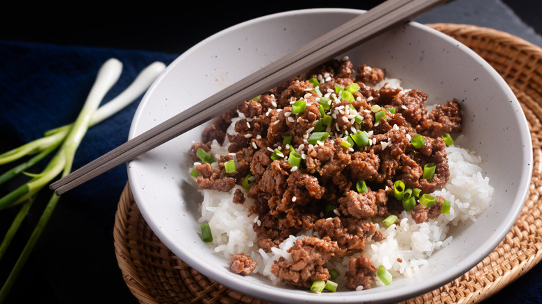 Bowl of rice and ground beef with chopsticks