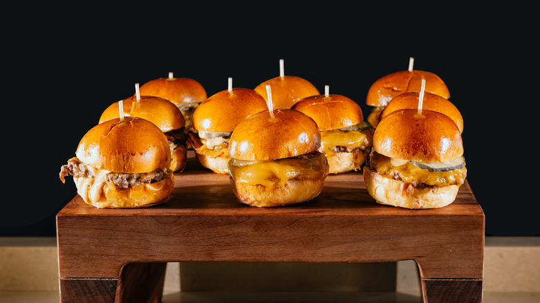 Mini cheeseburger sliders on wooden cutting board