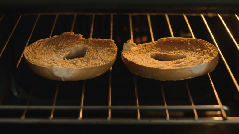 Bagels toasting in an oven grill.