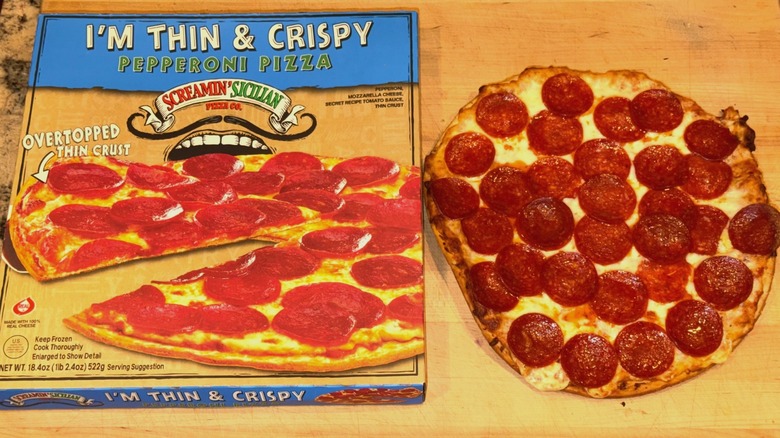Screamin' Sicilian I'm Thin & Crispy Pepperoni Pizza baked and placed on a wooden cutting board next to the box