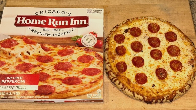 Chicago's Home Run Inn Premium Pizzeria Pepperoni Pizza baked and placed on a wooden cutting board next to the box