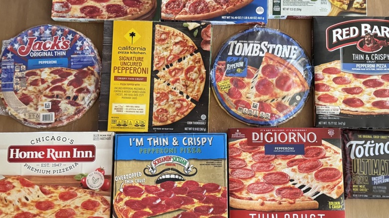 Variety of frozen thin crust pizza packages arranged on table