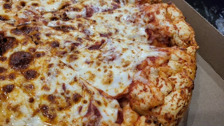 A Costco pizza gleams with greasy cheese in a box