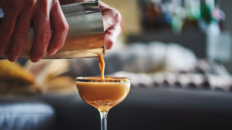 pouring espresso martini out of cocktail shaker